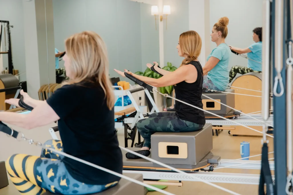 Women exercising on Pilates reformer machines at Pilates Franklin in Tennessee