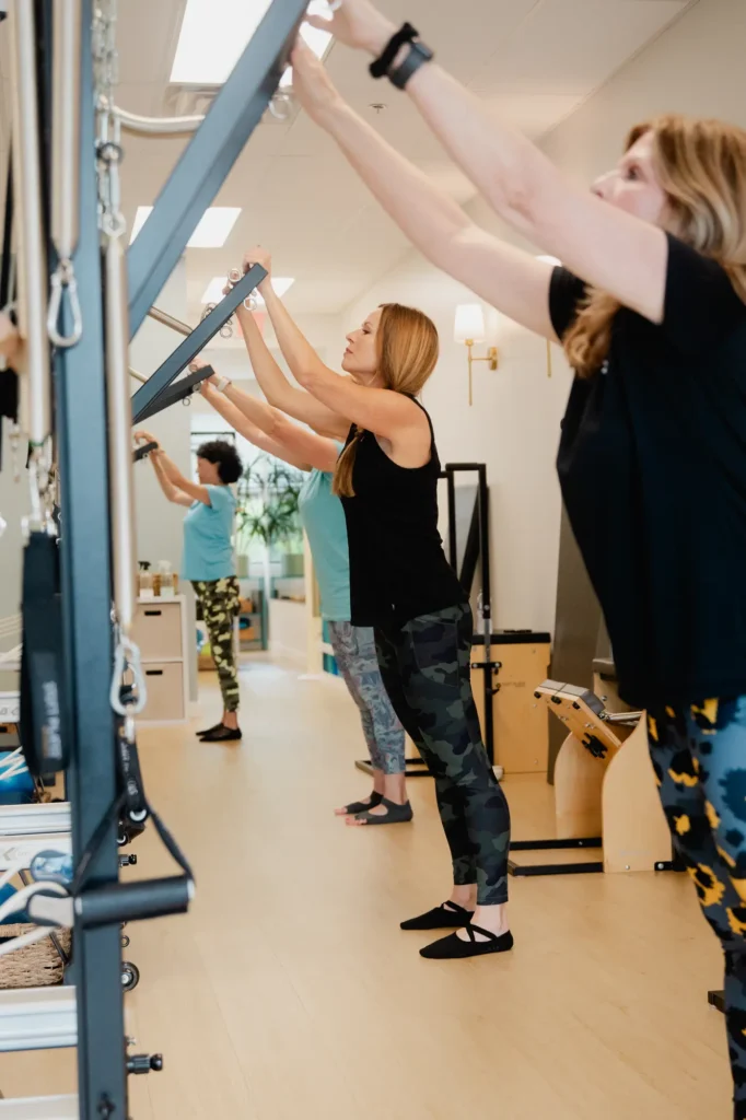 Women performing Pilates exercises on tower equipment at Pilates Franklin